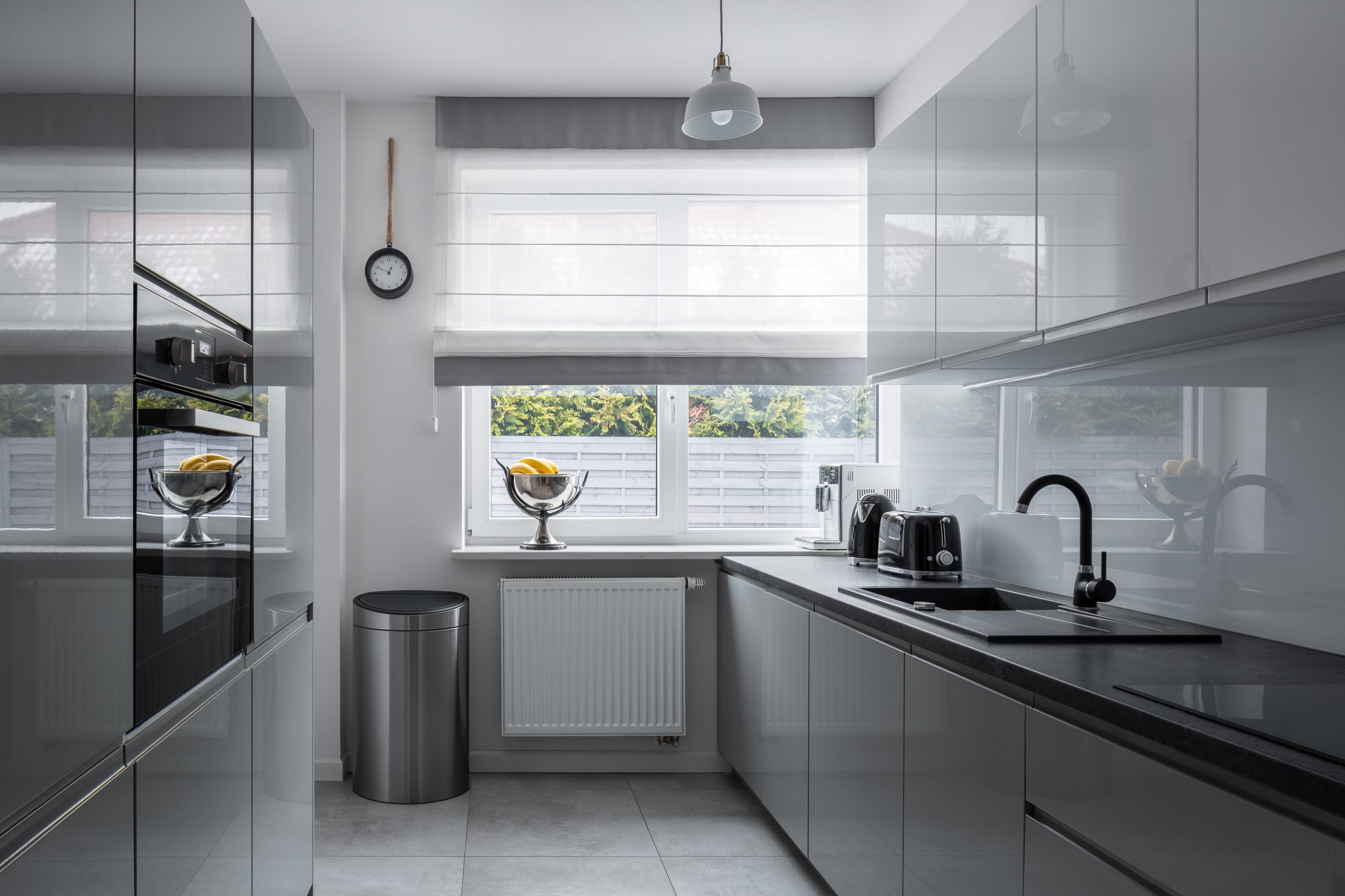 Narrow kitchen with window and modern, gray furniture